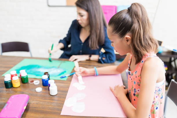 istock Girl And Mother Coloring Drawing Papers At Table 1018482468