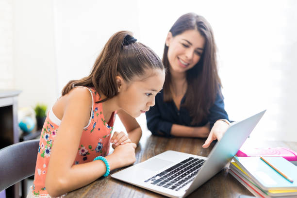 istock Girl And Teacher Using Laptop At Table 1018482510