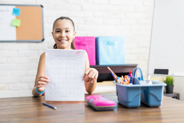 homework paper images Smiling School Girl Showing Perfect Test Result At Table Smiling school girl showing perfect test result at table in house homework paper stock pictures, royalty-free photos & images