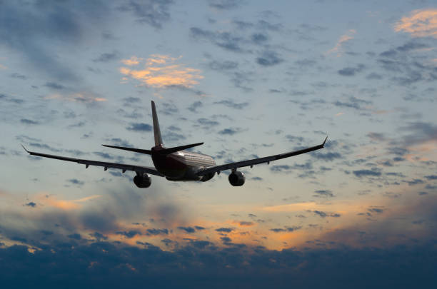 istock Airplane flying in sky with clouds at sunset time 1018493664