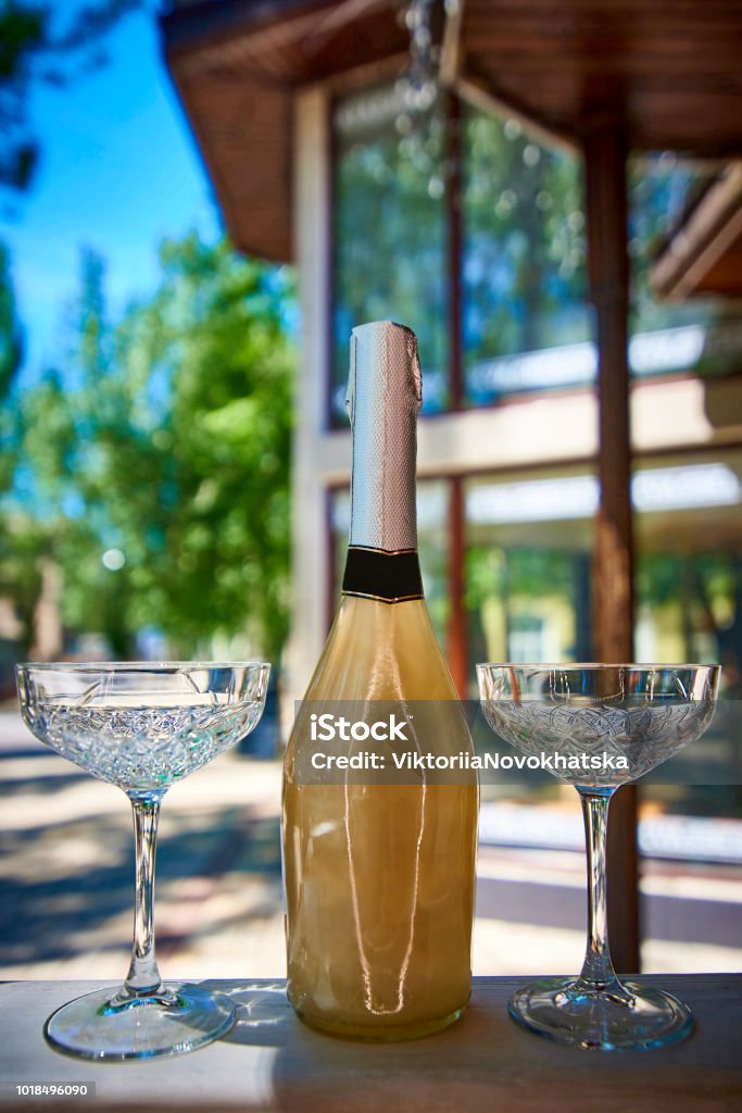 Champagne with crystal glasses on the summer terrace. Alcohol - Drink Stock Photo