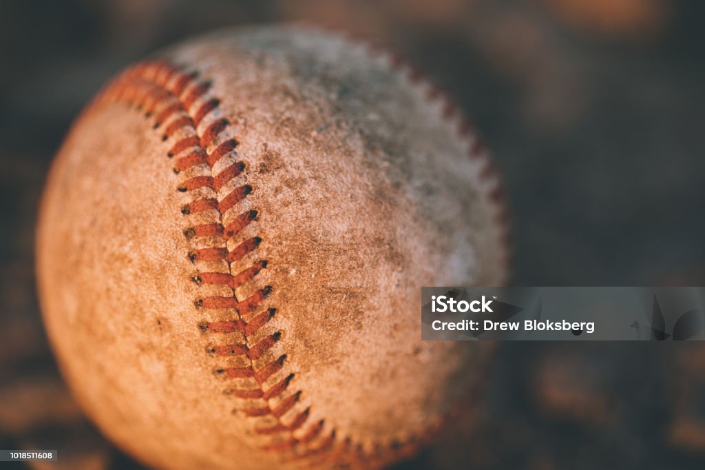 Baseball in the Sunset An old baseball in the dirtAn old baseball in the dirt High School Baseball Stock Photo