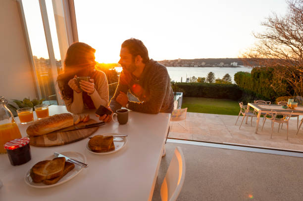 giovane coppia che beve caffè all'alba o al tramonto nella loro casa di lusso. - balcony house golf home interior foto e immagini stock