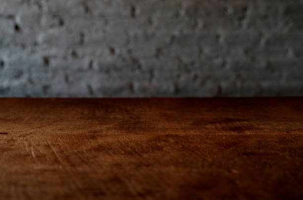 istock Empty top of wooden table or counter isolated on rustic focus wall brick Texture background. For product display 1018545834