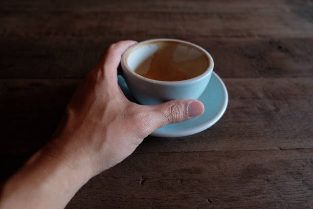 istock hands holding hot cup of coffee on rustic wooden table background 1018545968