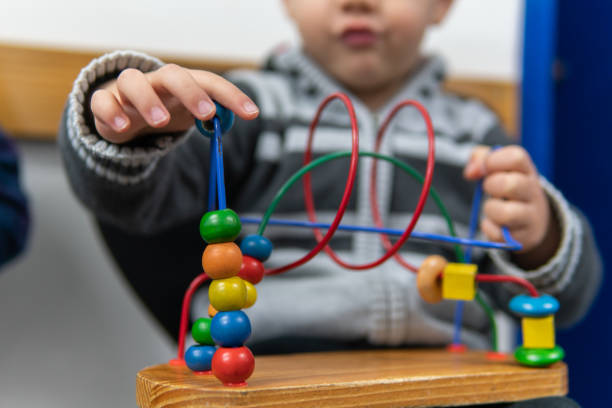 istock A little boy playing with a bead maze while sitting in a waiting room 1018548772