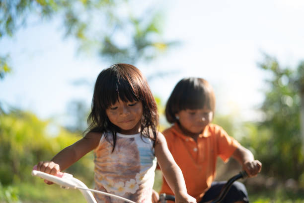 istock Two Children Riding a Bicycle in a Rural Place 1018552764