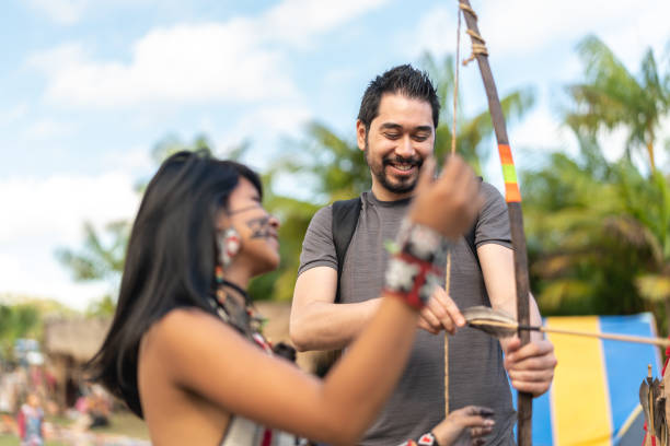 lezioni di apprendimento turistico, dalla tribù tupi guarani indigena, con arco e freccia, brasile - asian tribal culture immagine foto e immagini stock