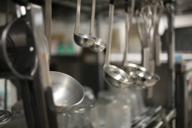 istock Ladles Hanging from a Stainless Steel Silver Metal Rack in an Industrial Kitchen 1018560310