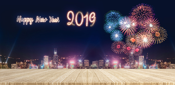 Happy new year 2019 fireworks over cityscape at night with empty wood plank table top,Mock up template for display or montage of product for holiday promotion advertising