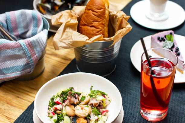 istock Lunch with seafood salad, drink, bread on the table in the cafe 1018599472