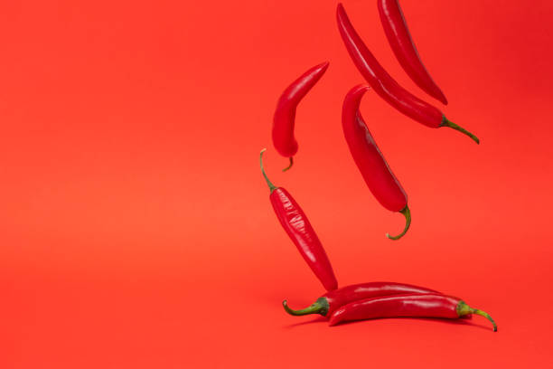 istock Red narrow long spicy chili peppers falling down 1018606484