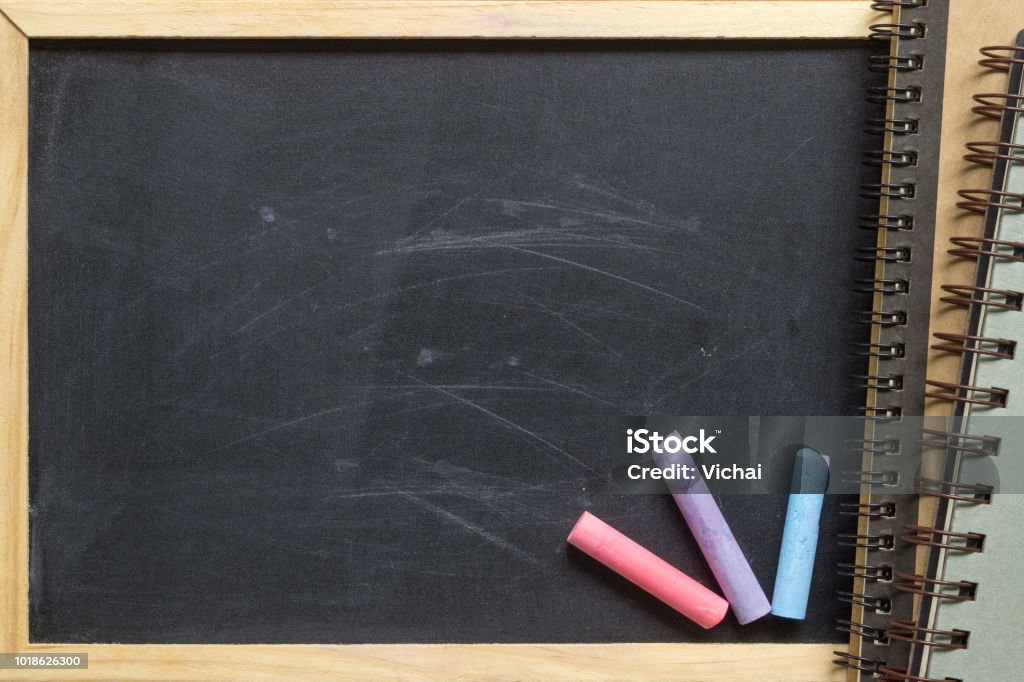 Empty Blank Black Chalk board Background with wooden frame and notebook, ideal for back to school and education background. Abstract Stock Photo