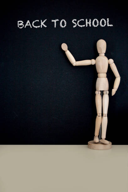 istock Mannequin pointing to blackboard with the text back to school 1018636368