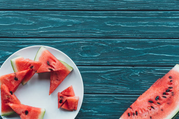 istock flat lay with fresh watermelon pieces on plate on blue wooden tabletop 1018637038