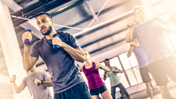 istock Aerobics group shadow boxing with dumbbells in a warehouse-gym 1018647936