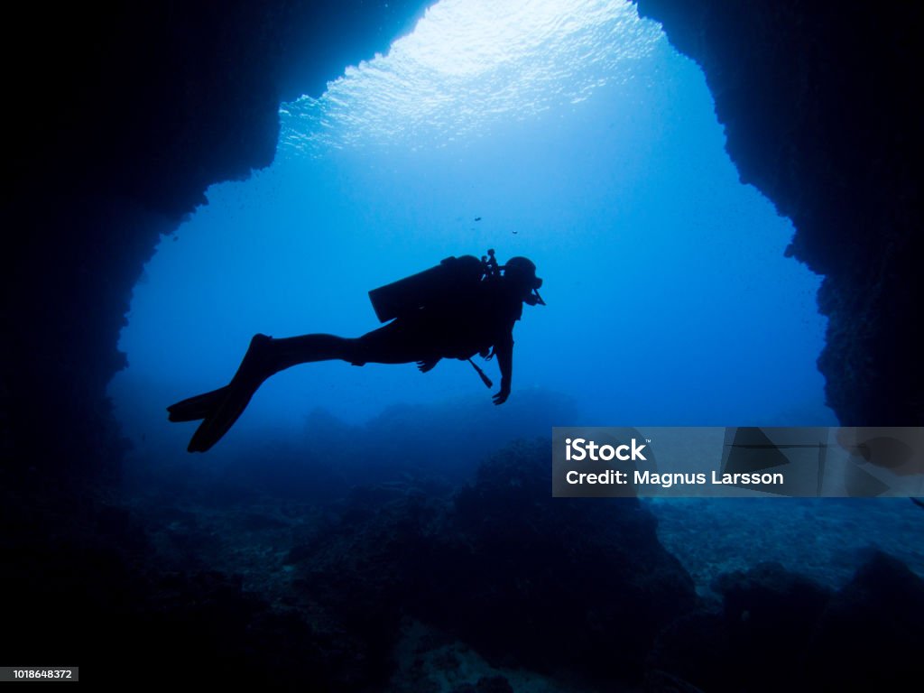 Cave diver silhuette Silhuette of a diver in an underwater cave Scuba Diving Stock Photo