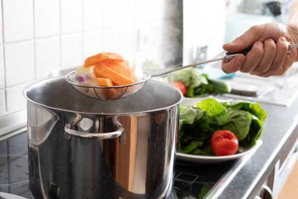 blanching vegetables in large cooking pot - colander imagens e fotografias de stock