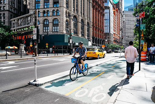 New York City, USA - June 20, 2018: Cyclist riding on bike lane in Park Row in Financial District