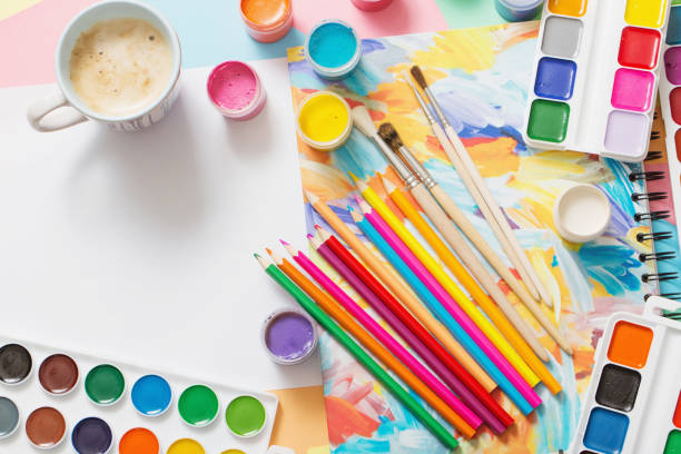 istock cup of coffee and paints, pencils on white background 1018659636