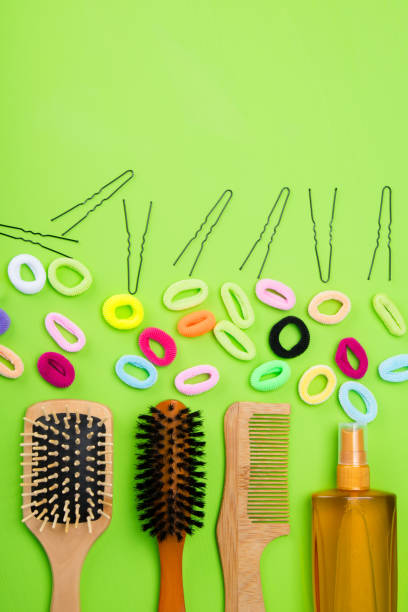 istock on a light green background are objects to create hairstyles. multi-colored rubber bands, black hairpins and combs. 1018663462