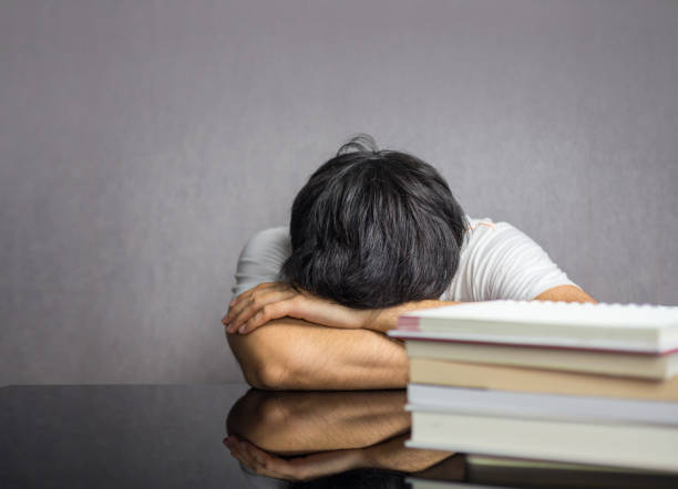 istock Man face down the table with books 1018674602