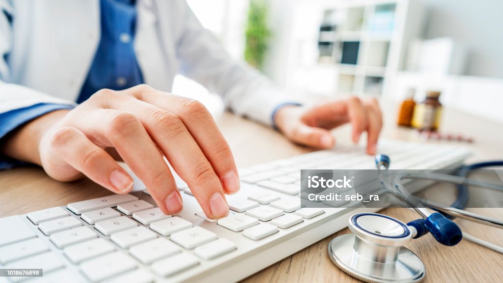 Medico donna che digita sul computer - Foto stock royalty-free di Medico