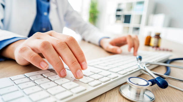 female doctor typing on computer - keyboard computer hands imagens e fotografias de stock