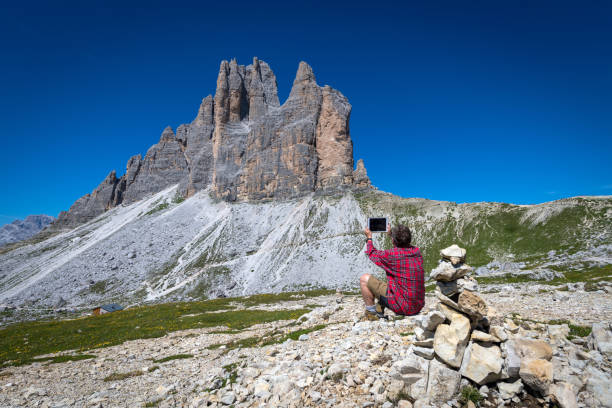 istock Senior Man Using Digital Tablet While Hiking around Tre Cime di Lavaredo in Dolomites, European Alps, Italy 1018677608
