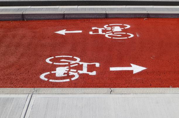 two-way cycle lane painted in red and white. the   directional arrows, after the bicycles symbol, indicating opposite directions - two way traffic imagens e fotografias de stock