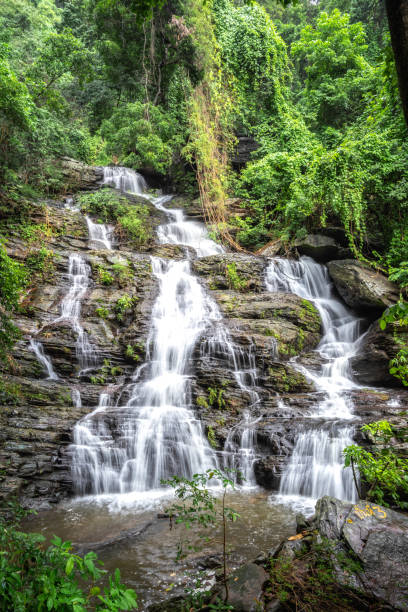 istock Beautiful large waterfall flowing between rocks in a deep green forest. Waterfall flowing over rocks. Nature background. 1018683220