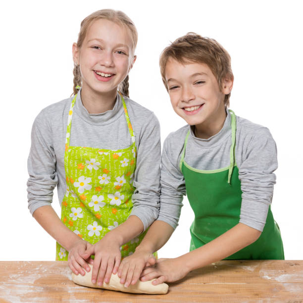 istock boy and girl roll out dough for baking, laugh, have fun, on white background, isolate 1018683936