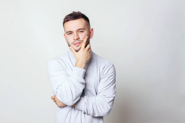 istock Portrait of a handsome young man thinking on something, isolated on gray background 1018697904