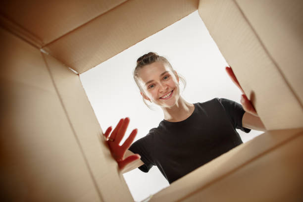istock Woman unpacking and opening carton box and looking inside 1018700084
