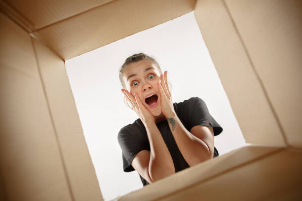 istock Woman unpacking and opening carton box and looking inside 1018700116