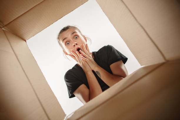 istock Woman unpacking and opening carton box and looking inside 1018700178