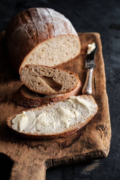 istock Fresh bread and homemade butter on dark background 1018706836