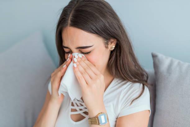 istock Young woman blowing her nose 1018707224