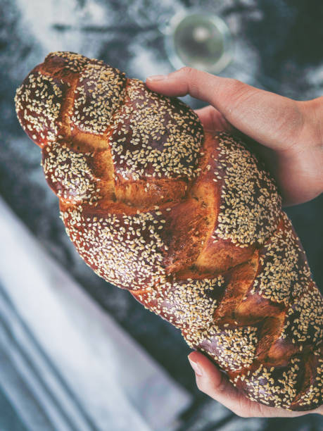 Woman hands holding tasty fresh bread, top view.