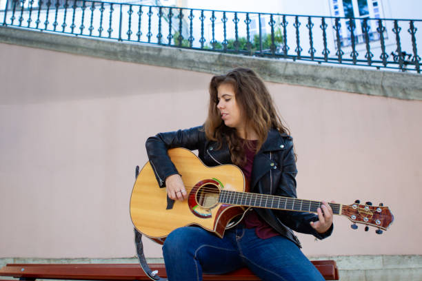 istock Positive rock singer playing guitar on street 1018707624