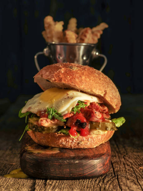 istock Burger with chopped meat, egg and arugula on a wooden table 1018711108