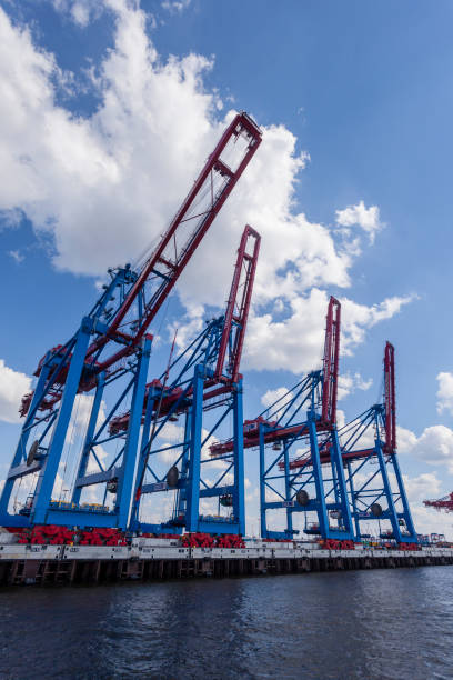 A shipyard with cranes at sunset light with dramatic stormclouds, graphic effect