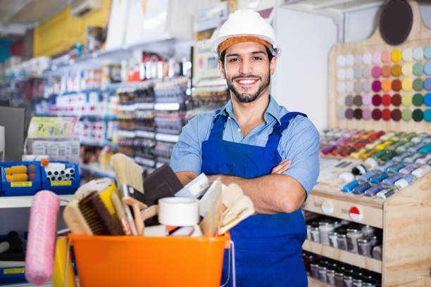 istock Workman standing folded arms near basket with picked tools in paint store 1018715456