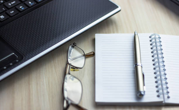 istock Office workplace with text space, White wooden table with office supplies tablet, desktop computer and book, top view, over light 1018719094