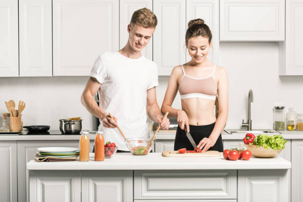 istock young couple cooking salad together in kitchen 1018721822
