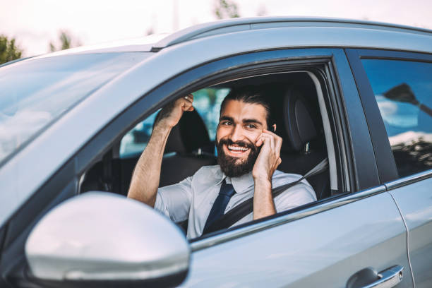 istock Handsome businessman talking on the phone while waiting in the car 1018730982
