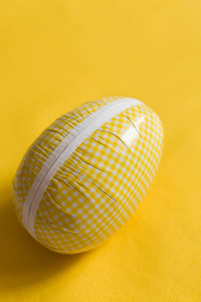 Easter egg box with candy and chocolate, scandinavian tradition. close up on yellow backgorund.  big Easter egg full of sweets and cookies. celebrating Easter. easter surprise.