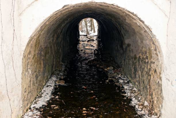 istock old gray concrete tunnel with water flow 1018732672