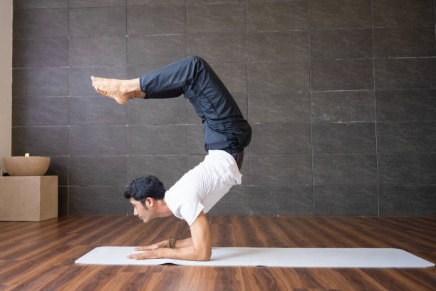 istock Experienced yogi doing scorpion yoga pose in gym 1018739584