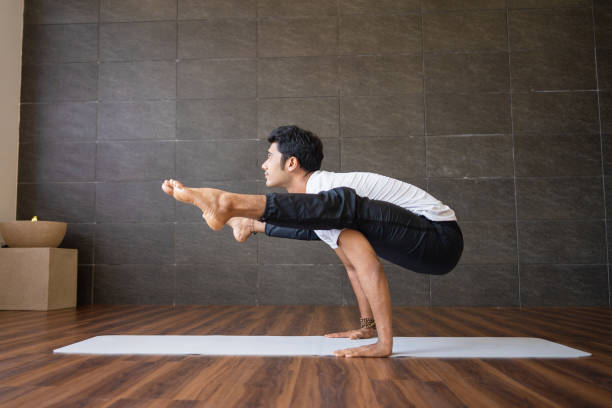 istock Indian yogi doing firefly yoga pose in gym 1018739610